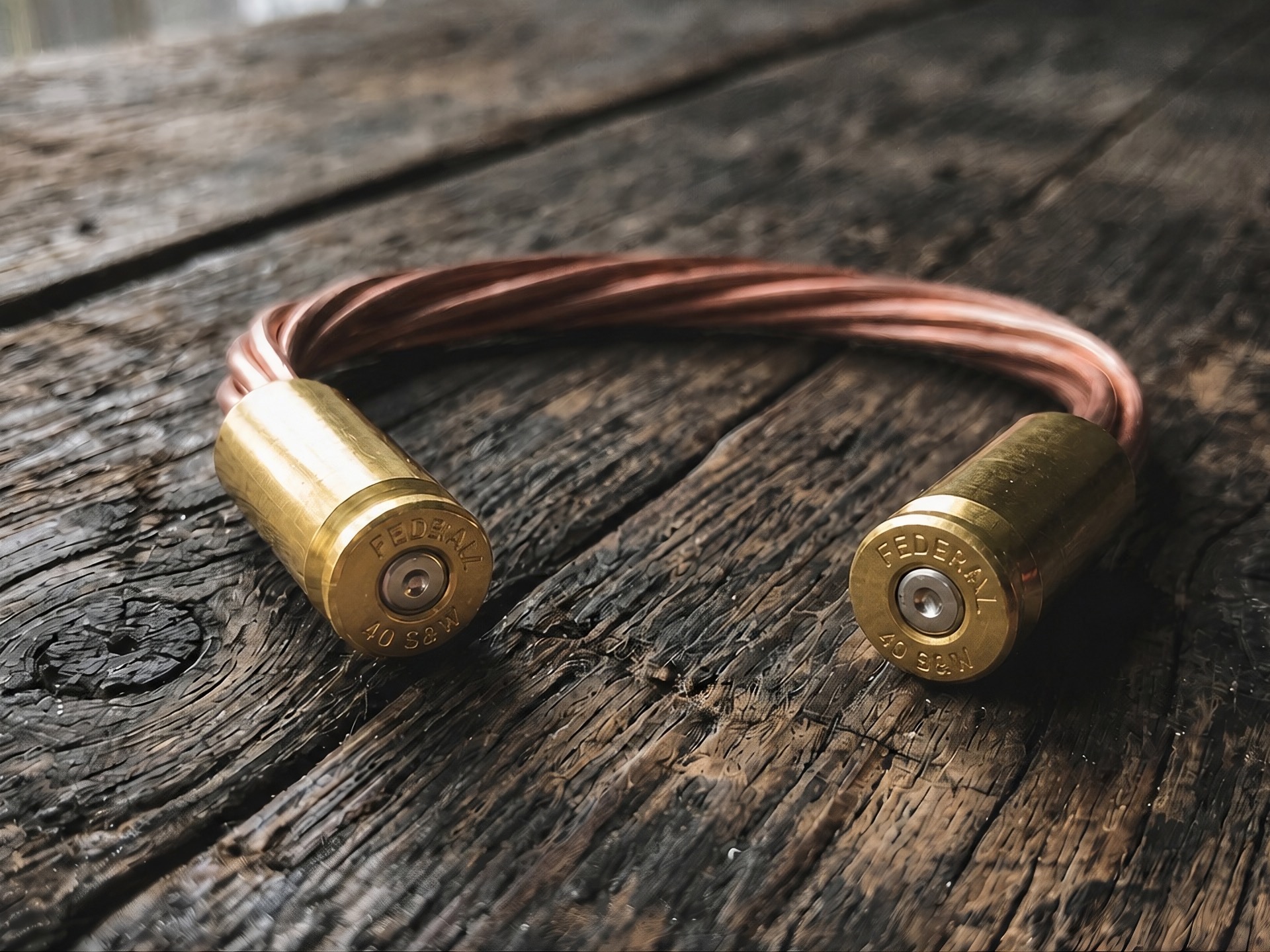 Copper bracelet with brass casings on weathered wood